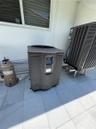 Exterior mechanical systems featuring a heat pump and additional outdoor unit, situated on a tiled surface