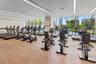 Fitness center featuring wood-finish flooring, floor-to-ceiling windows, and recessed linear lighting