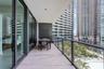 Covered balcony featuring wood-finish tile flooring, glass railings, and expansive sliding glass doors