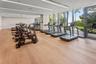 Fitness center featuring wood-finish flooring, floor-to-ceiling windows, and recessed linear lighting