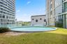 Circular outdoor pool featuring a glass balustrade surround and lawn landscaping