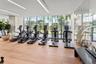 Fitness center featuring floor-to-ceiling windows, wood-finish flooring, mirrored wall, and recessed linear lighting