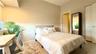 Bedroom featuring neutral-toned walls, wood-finish flooring, and a built-in closet with sliding doors