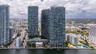 High-rise residential towers featuring glass-curtain wall construction, waterfront location, and multi-level outdoor podium pool area