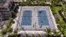 Dual-court tennis facility featuring perimeter chain-link fencing, high-mast lighting, and surrounding palm tree landscaping