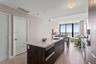 Kitchen featuring a central island with a solid surface countertop, wood-finish cabinetry, built-in microwave, wood-finish flooring, and floor-to-ceil