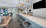 Stone-surfaced bar counter with integrated recessed display wall, wood-finish flooring, and multi-pendant lighting