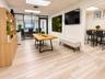 Wood-finish flooring, built-in light wood cabinetry, ceiling-mounted recessed lighting, and a black-framed glass wall partition