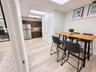 Kitchenette featuring wood-finish cabinetry, stainless steel refrigerator, drop ceiling with recessed lighting, and wood-finish flooring