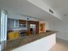 Kitchen featuring wood cabinetry, stone countertops, stainless steel appliances, a breakfast bar, and tile flooring
