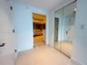 Large-format tile flooring, dual-panel mirrored closet doors, and solid-core interior doors