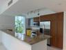 Kitchen featuring stone countertops, breakfast bar, built-in cabinetry with glass-panel upper doors, stainless steel appliances, and track lighting