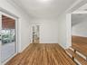 Wood-finish flooring, crown molding, glass-paned exterior door, and elevated platform featuring decorative tile accents
