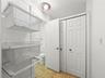 Wood-finish flooring, white paneled closet doors, and wall-mounted metal wire shelving system with flush-mount ceiling lighting
