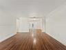 Interior space featuring wood-finish flooring, crown molding, and neutral wall paint