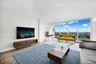 Floor-to-ceiling windows, wood-finish flooring, and expansive urban scenery