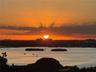 Panoramic water landscape featuring a sunset backdrop, open bay, and prominent tree-lined islands