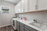 Laundry room with storage cabinets and utility sink