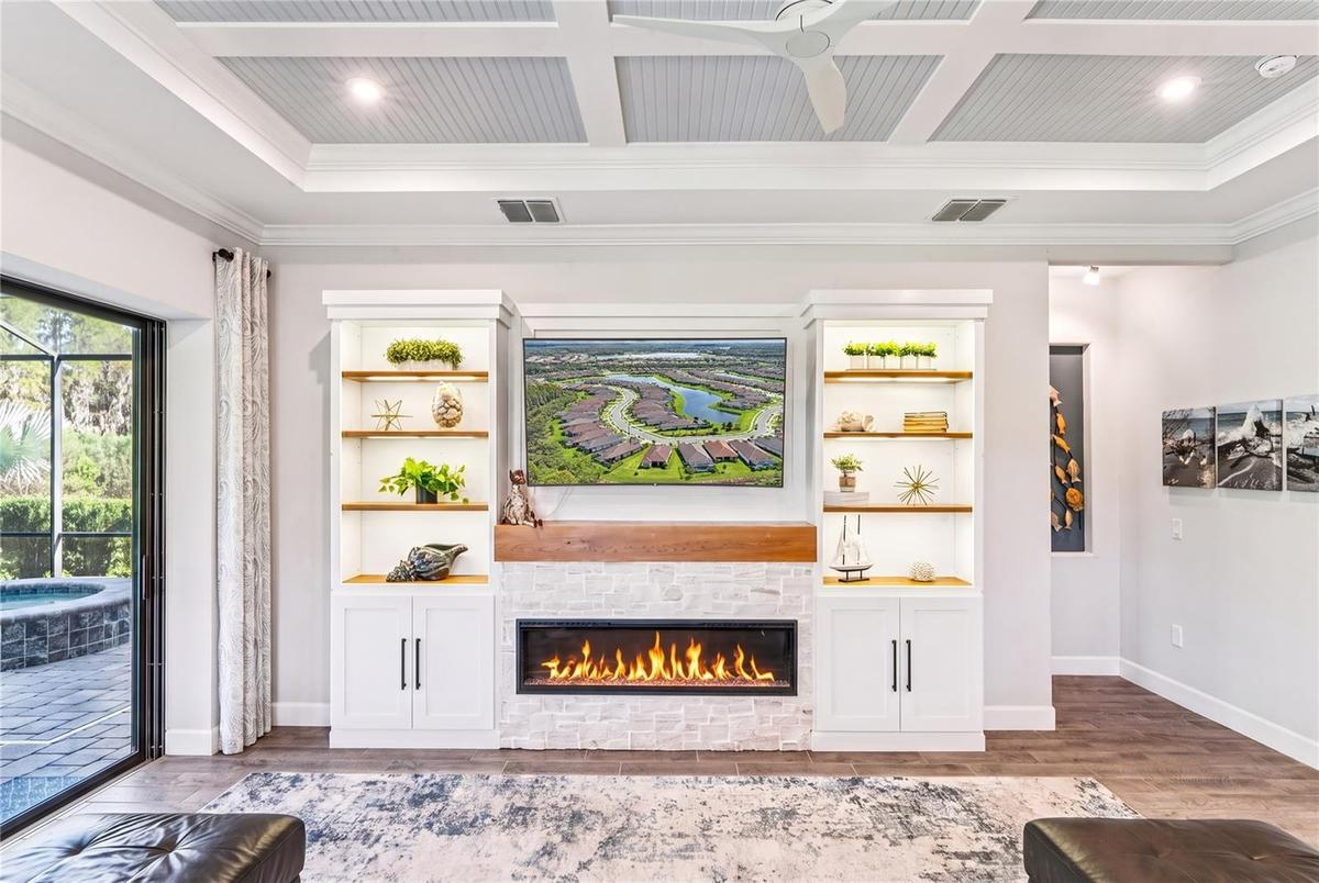 Custom built TV wall with stone, wood shelves, and Fireplace