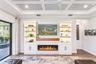 Custom built TV wall with stone, wood shelves, and Fireplace