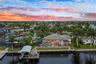 Aerial evening view of the back of the house, plus the dock, tiki and lift
