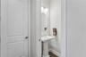 Half bath in hallway leading out to garage