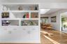 Living room is accented with custom cabinetry and gleaming oak floors.