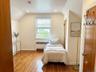 Room with hardwood flooring, recessed ceiling lighting, a window with horizontal blinds, and a custom-fitted radiator cover