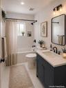 Bathroom featuring a navy vanity cabinet with a light-toned countertop, rectangular wall-mounted mirror with a black frame, recessed wall niche, and m