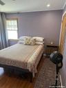 Wood-finish flooring, recessed lighting, and a single-hung window with natural wood trim