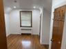 Room featuring wood-finish flooring, recessed lighting, and a single window with wood trim
