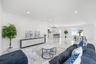 Open-concept interior featuring large-format tile flooring, recessed lighting, and a kitchen island with stone-finish countertops