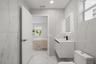 Full-height stone-finish wall tile, floating vanity with an integrated sink, matte black faucet, and backlit LED mirror
