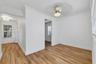 Wood-finish flooring, crown molding, and ceiling fan with integrated light fixture