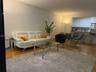 Covered balcony featuring concrete flooring, a solid masonry partial wall, and a metal railing