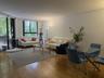Open-concept living space featuring wood-finish flooring, floor-to-ceiling sliding glass doors, and expansive windows