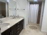 Kitchen featuring flat-panel cabinetry, stone countertops with a matching full-height backsplash, wood-finish flooring, and stainless steel appliances