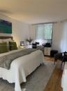 Living area featuring wood-finish flooring, floor-to-ceiling sliding glass doors, and a private balcony