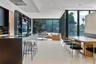 Open-concept interior featuring floor-to-ceiling glass walls, large-format tile flooring, recessed ceiling lighting, and custom built-in shelving