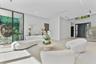 Open-concept living space featuring large-format tile flooring, floor-to-ceiling glass panel walls, recessed ceiling lighting, and a staircase with op