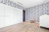 Room featuring floor-to-ceiling white cabinetry, wood-finish flooring, patterned wallpaper, recessed lighting, and a dark-finish door