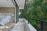 Private balcony with stone flooring, metal railings, recessed lighting, and large-format sliding glass doors