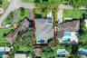 Aerial view of residential property featuring a hip roof, private swimming pool, paver driveway, and mature landscaping