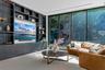 Custom dark-toned, floor-to-ceiling built-in cabinetry featuring integrated shelving, floor-to-ceiling glass walls, large-format tile flooring, and re