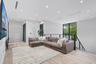 Open-concept space featuring light wood-finish flooring, recessed ceiling lighting, linear HVAC diffusers, and a staircase with a horizontal cable rai