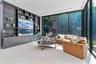 Living space featuring floor-to-ceiling glass walls, built-in custom dark wood cabinetry with integrated glass shelving, recessed lighting, and large-