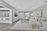 Open floor plan featuring wood-finish flooring, recessed lighting, and a breakfast bar with stone countertop