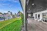 Waterfront property featuring a private boat dock, retractable glass wall system, recessed lighting, wood-finish flooring, and a built-in wet bar