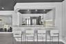 Kitchen featuring a peninsula with a stone-surfaced countertop, integrated under-cabinet lighting, full-height stone backsplash, flat-panel cabinetry,