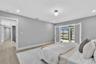 Neutral-toned interior featuring wood-finish flooring, recessed lighting, double glass-panel doors, and sliding glass doors with exterior water exposu